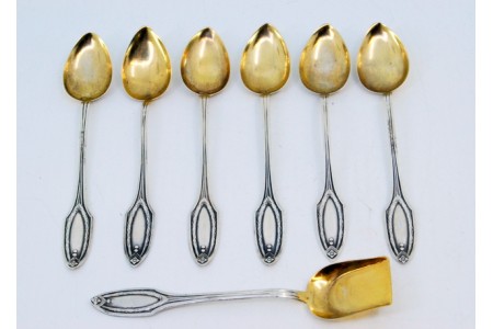 Conjunto de seis colheres de café e pá de açúcar em prata com relevos nos cabos e nas conchas douradas.